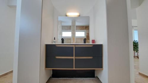 a bathroom with a sink and a mirror at Azot Villa in Le Tampon