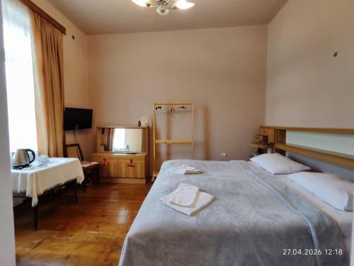 a bedroom with a bed and a table and a window at MariElla in Akhaltsikhe