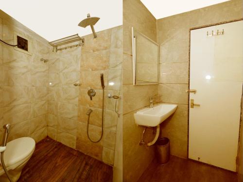 a bathroom with a shower and a toilet and a sink at N S International in Kolkata