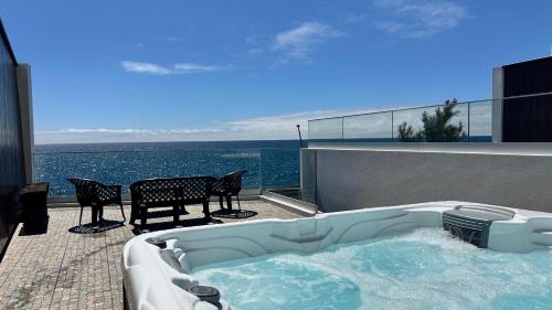 a hot tub on the balcony of a house with the ocean at South Shore 1 - HOST & CHILL in São Roque