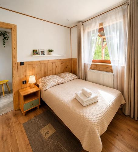 a bedroom with a bed with two towels on it at Portki - Cztery Pory Roku in Pszczeliny