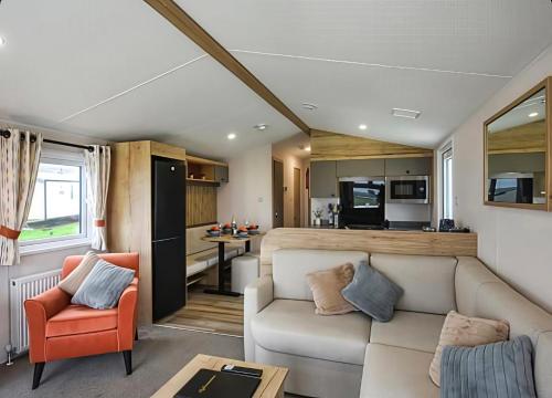 a living room with a couch and a kitchen at 26 Ocean View in Llwyngwril