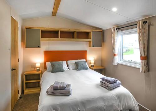 a bedroom with a bed with two towels on it at 26 Ocean View in Llwyngwril