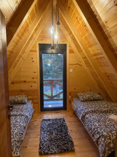 two beds in a room with a window at Black Pine Chalet in Meždo