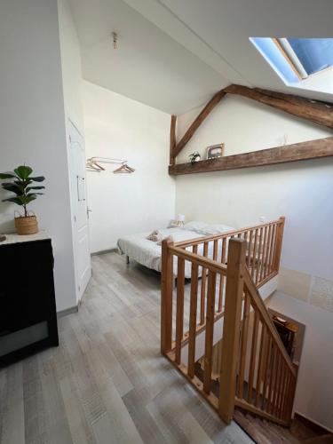 a attic bedroom with a bed and a staircase at L'Aile de Fontainebleau in Fontainebleau