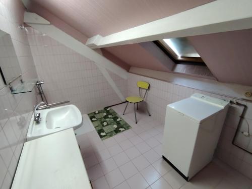 a bathroom with a sink and a yellow chair at VIDAL BERNARD in Saint-André-de-Vézines