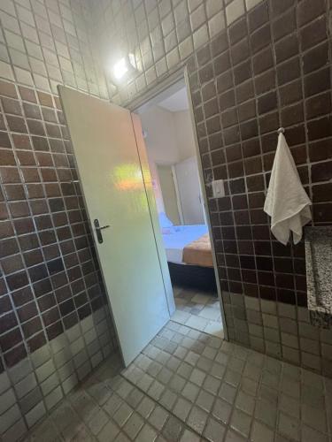 a bathroom with a door leading to a bedroom at Pousada Pedra que Canta in Itamaracá