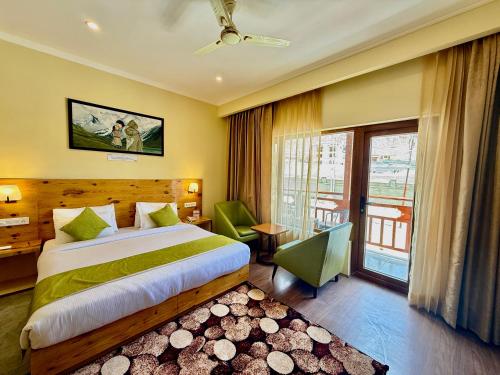 a hotel room with a bed and a balcony at Crown Himalaya in Leh