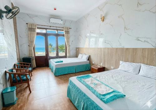 a bedroom with two beds and a view of the ocean at Khách sạn Hồ Gươm in Sầm Sơn