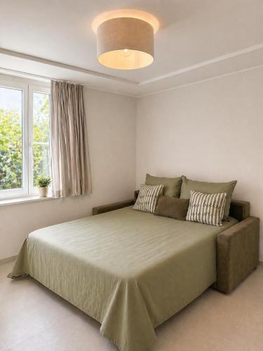 a bedroom with a large bed and a large window at NAIA apartment in Koper