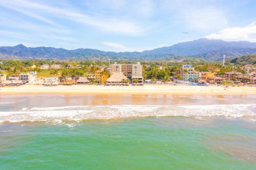 a view of a beach with buildings and the ocean at Decameron Isla Coral Guayabitos, Ramada All-Inclusive Resort in Rincon de Guayabitos