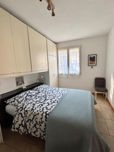 a bedroom with a bed with a black and white comforter at Appartamento Nuvola Bianca 1 in Cesenatico
