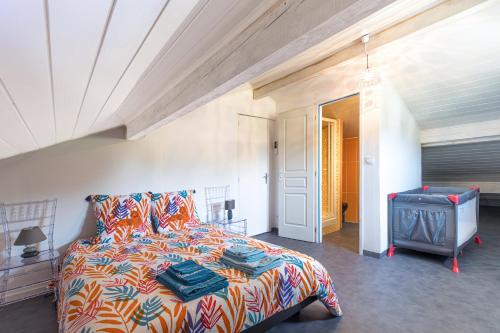 a bedroom with a bed with a colorful comforter at Villa 4 Saisons, piscine chauffée in Vieux-Boucau-les-Bains