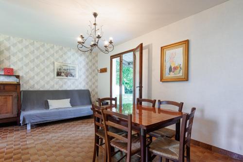 a dining room with a table and a bed at Villa L'Andélu - Conciergerieland in Saint-Michel-Escalus