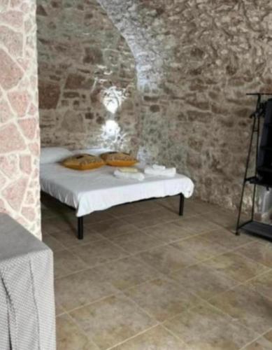 a bedroom with a bed in a stone wall at Stradone centrale in Vieste