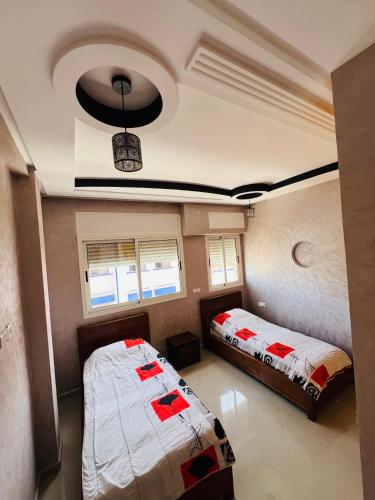 a bedroom with two beds and a ceiling at Chez Yamaa in Oualidia