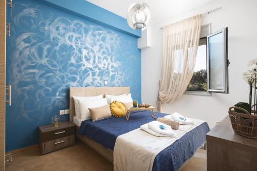 a bedroom with a blue accent wall and a bed at Royal Touch Suite in Loutra