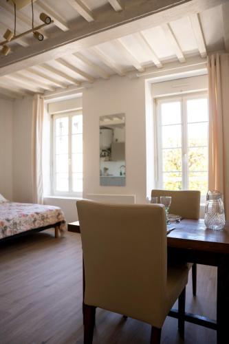a room with a table and chairs and a bed at Studio Saint-Patrice - centre historique Bayeux in Bayeux