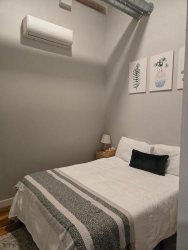 a bedroom with a bed and a air conditioner at Historic Federal Hill 1Br Loft apt with onsite Gym and Barbershop in Providence