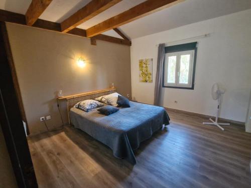 ein Schlafzimmer mit einem Bett mit blauer Bettwäsche und einem Fenster in der Unterkunft le verso in Narbonne