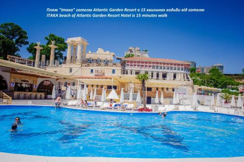 a pool at a hotel with people in the water at Atlantic Garden Resort in Odesa
