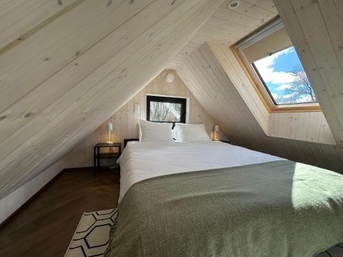 a bedroom with a large bed in a attic at Greencabin - Cabin Escape in the Heart of Saaremaa in Pamma