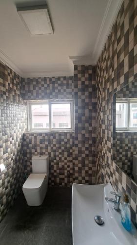 a bathroom with a toilet and a sink at Sea View Haven in Accra