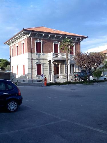 budynek z samochodem zaparkowanym przed nim w obiekcie Mansarde in Villa w mieście Civitanova Marche