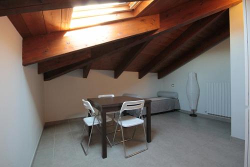 ein Esszimmer mit einem Tisch und weißen Stühlen in der Unterkunft Mansarde in Villa in Civitanova Marche