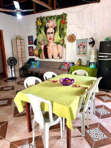 a kitchen with a table and a painting of a woman at Casa rosa in Maracanã