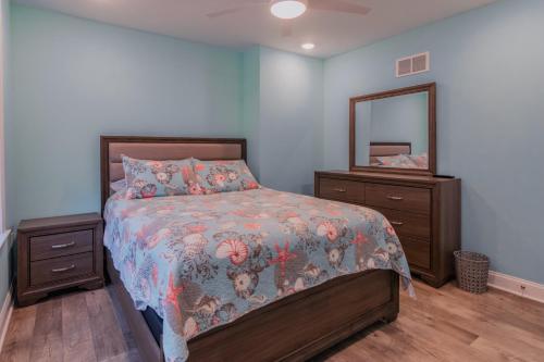 a bedroom with a bed with a dresser and a mirror at The Royal Treat in Lavallette
