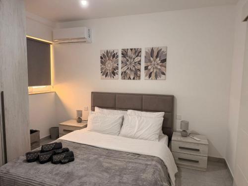 a bedroom with a bed and two paintings on the wall at 11 Rose in Sannat