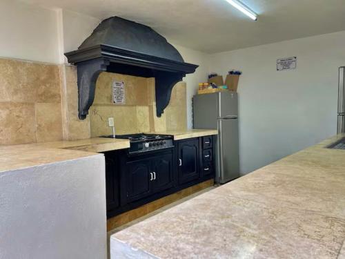 a kitchen with a stove and a refrigerator at Comodo Estudio 8 in El Gallinero