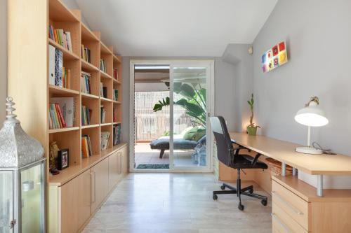 an office with a desk and book shelves at Duplex Beach Masnou in El Masnou