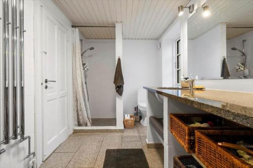 a bathroom with a tub and a sink and a shower at 20229-Samso-Byvejen-20 in Hårdmark