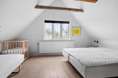 a white bedroom with a bed and a window at 20622-Samso-Skolebakkevej-38 in Brundby