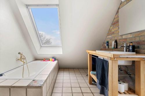 a bathroom with a bath tub and a window at 20622-Samso-Skolebakkevej-38 in Brundby