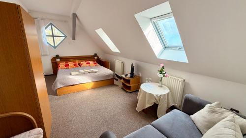 a small bedroom with a bed and a couch at Motel Dareon in Náchod