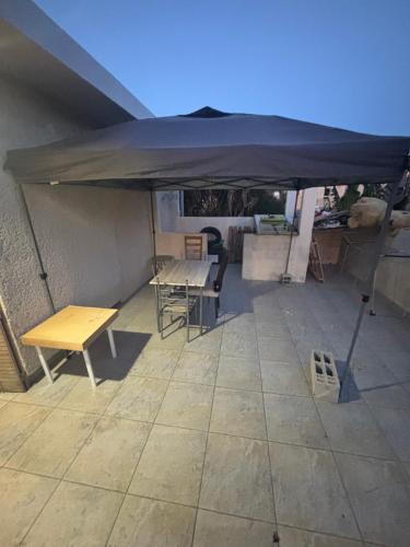 a table and chairs under an umbrella on a patio at Logement catalan in Perpignan