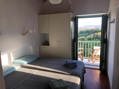 a bedroom with a bed and a balcony with a view at To Ampeli in Potamós