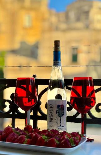 a bottle of wine and two glasses on a table at Radici - La finestra sui Sassi in Matera