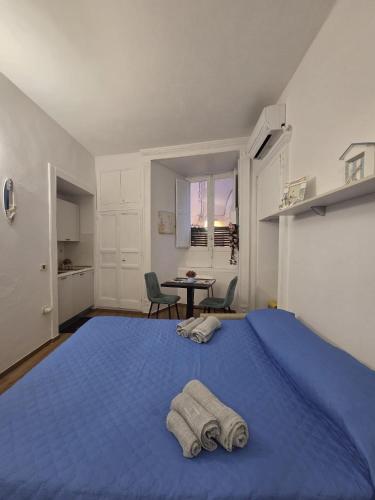 a bedroom with a blue bed with two towels on it at Mare Fuori Apartment in Tropea