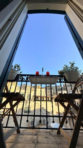 a table and chairs on a balcony with a view at Radici - La finestra sui Sassi in Matera
