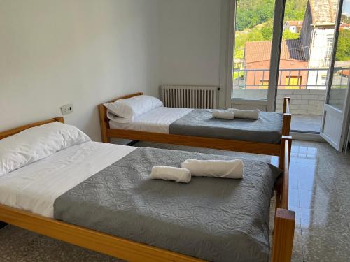two beds with towels on them in a bedroom at pensión Palongo in Caldas de Reis