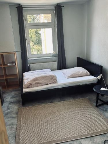 two beds in a room with a window and a rug at Stadtwohnung Mettmann in Mettmann