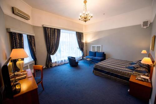 a hotel room with a bed and a couch at Grand Hotel Ukraine in Dnipro