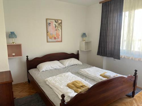 a bedroom with a bed with white sheets and a window at Apartment Bedem Center in Bihać