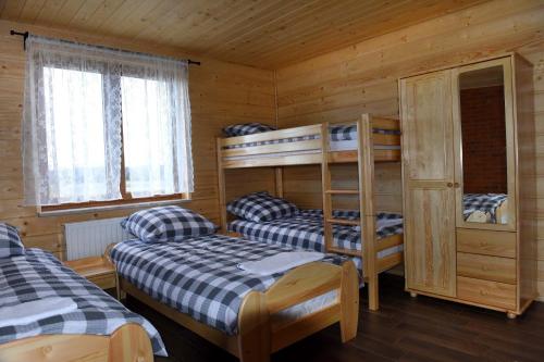 a bedroom with two bunk beds in a cabin at Agroturystyka Rumcajsówka in Bałtów