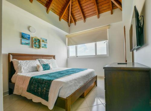 a bedroom with a bed and a television and a window at PENTHOUSE AGUAMARINA in San Andrés
