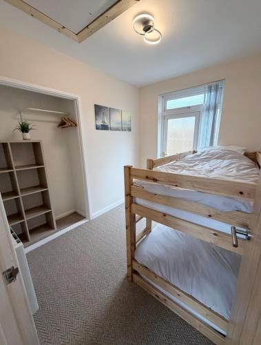 a bedroom with a bunk bed and a window at Bungalow in Mumbles in The Mumbles